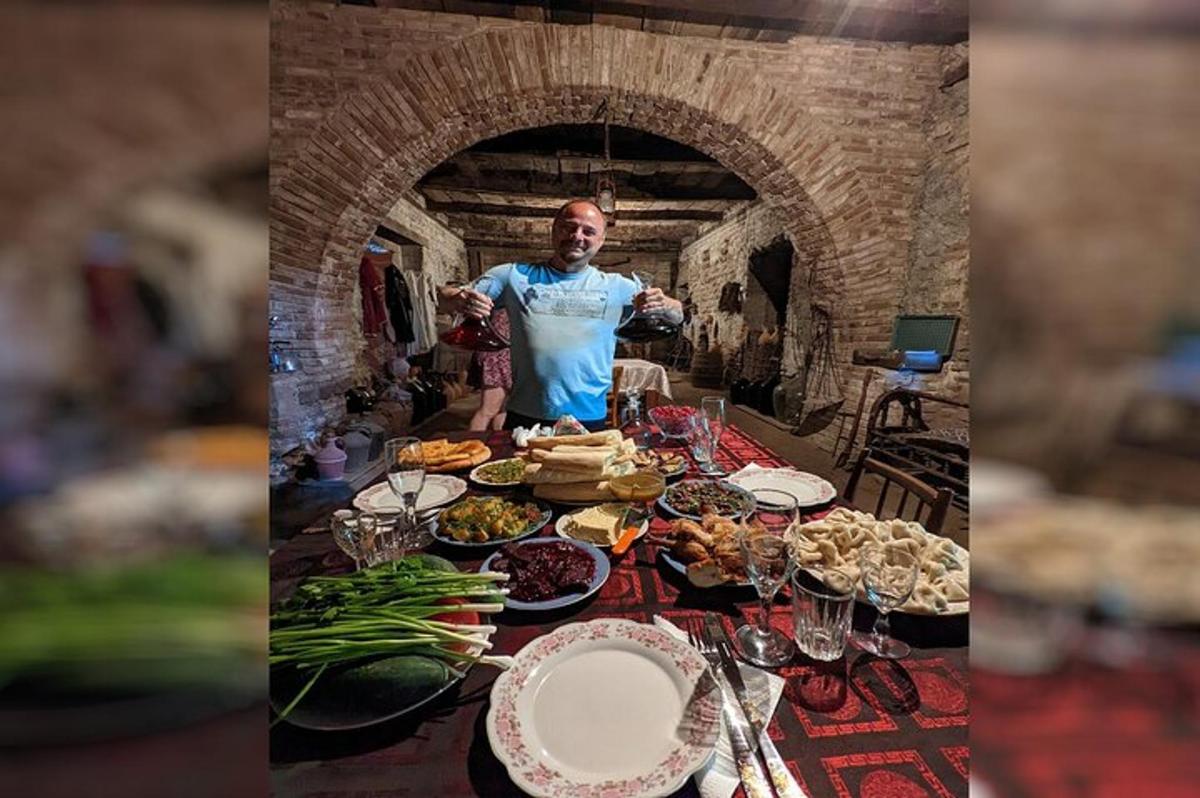 Un hombre parado frente a una mesa llena de comida.