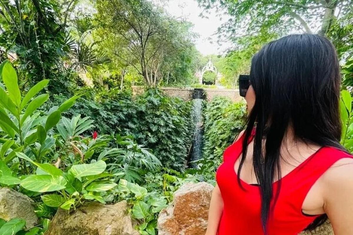 una donna in un vestito rosso che guarda un giardino