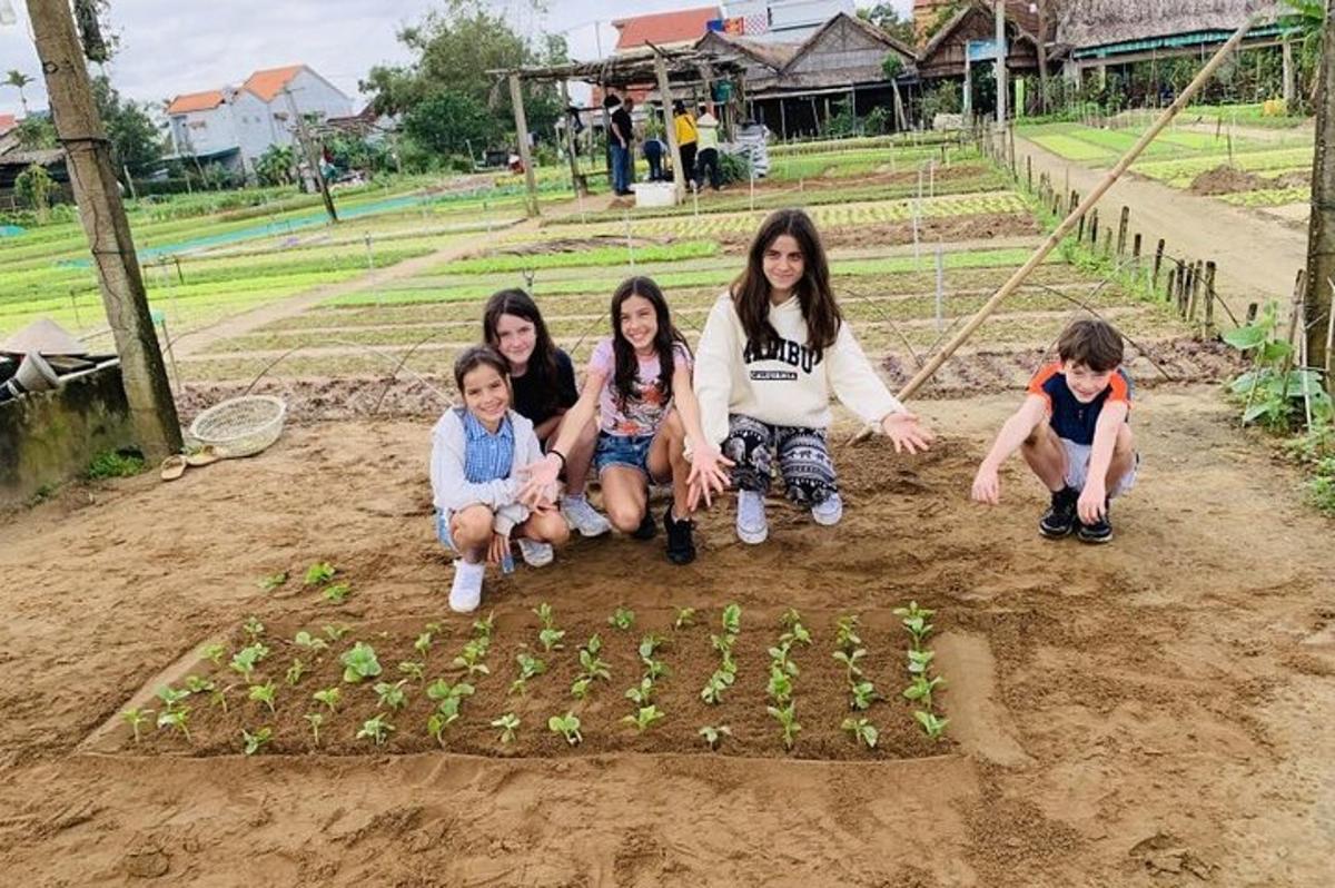 sekumpulan kanak-kanak perempuan dan kanak-kanak melutut di sekeliling taman