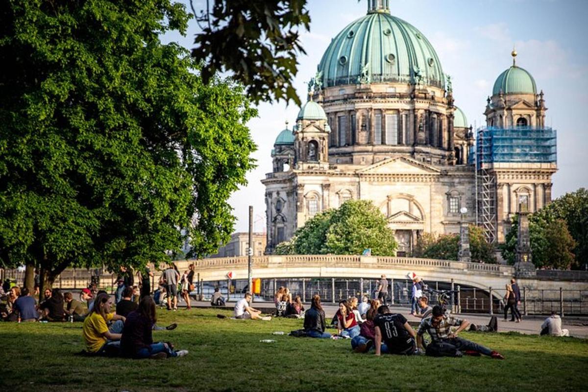 people sitting in the grass in front of a building