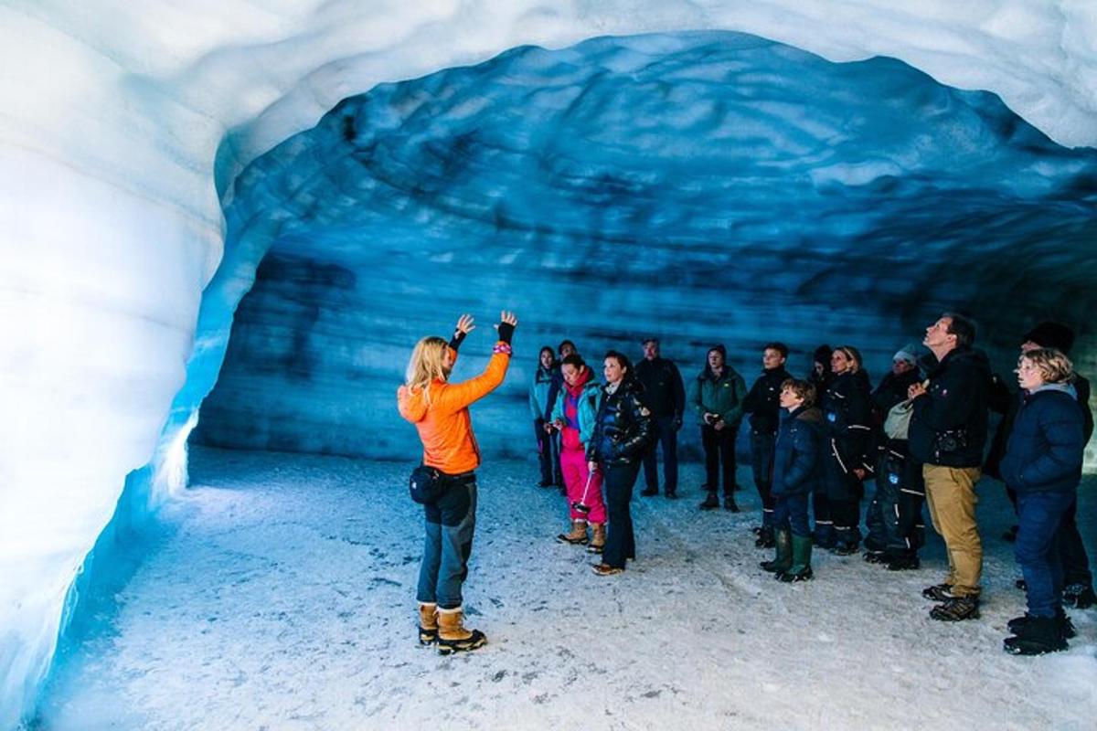 un gruppo di persone in piedi all'interno di una grotta di ghiaccio
