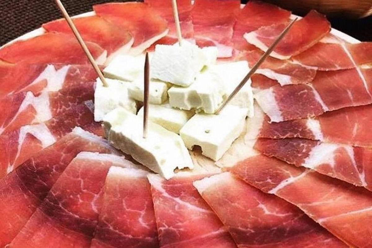 un piatto di cibo con carne e formaggio sopra