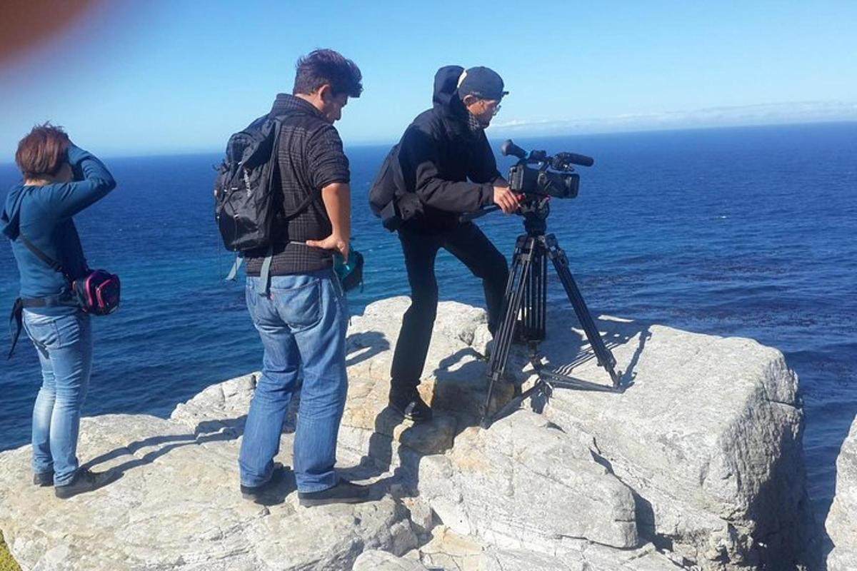 un grup de persones dretes sobre una roca amb una càmera