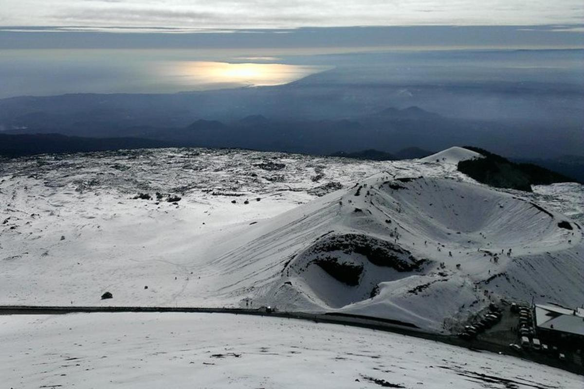 ein schneebedeckter Berg mit der Sonne im Hintergrund