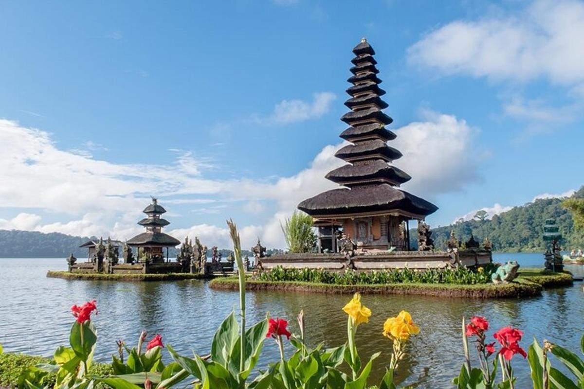 a pagoda in the middle of a lake with flowers
