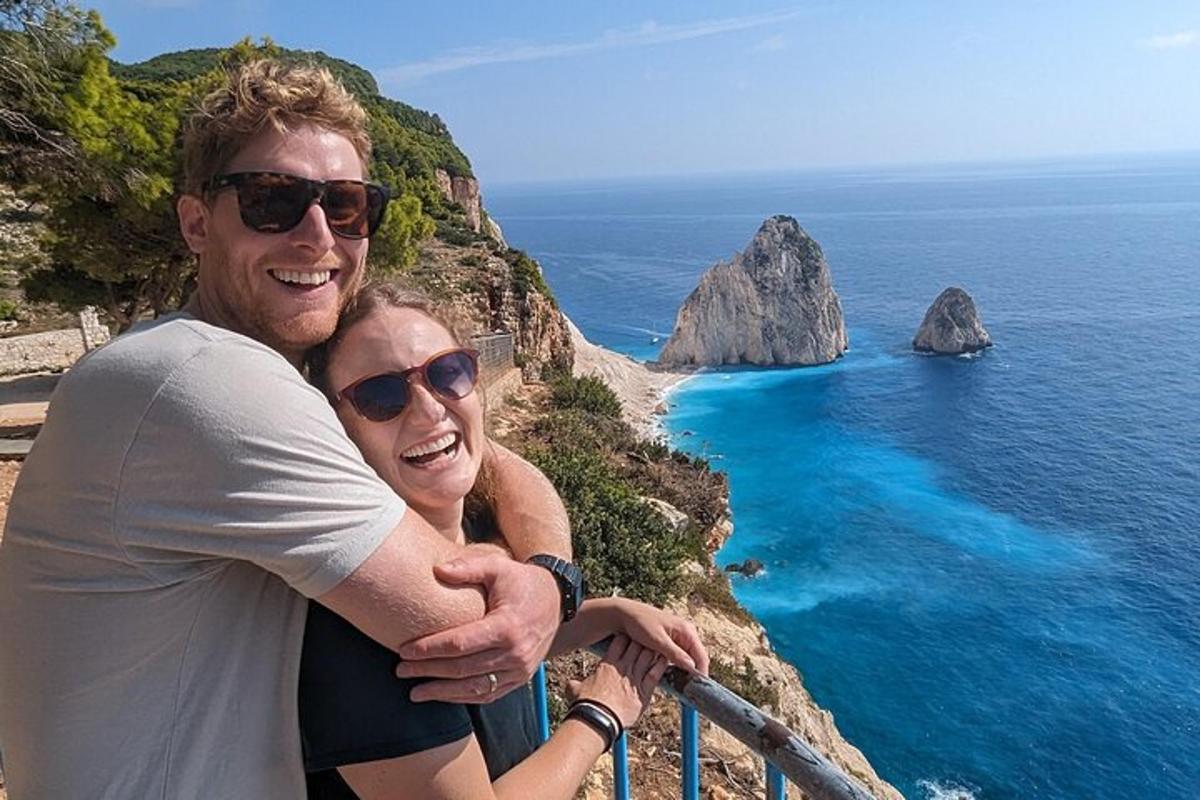 muž a žena stojaci na rímse s výhľadom na oceán