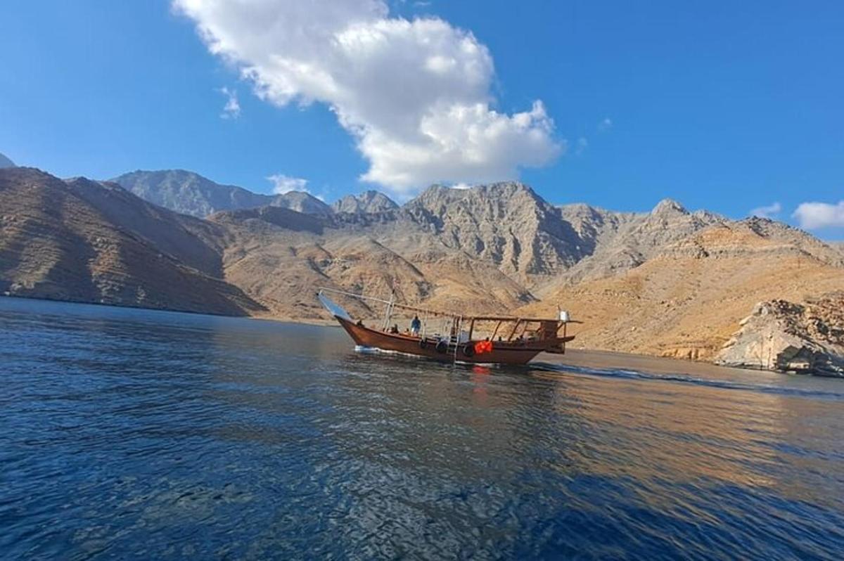 a boat on the water with mountains in the background