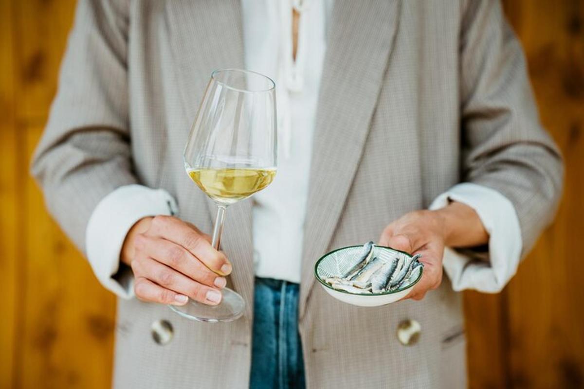 moški v obleki, ki drži kozarec vina