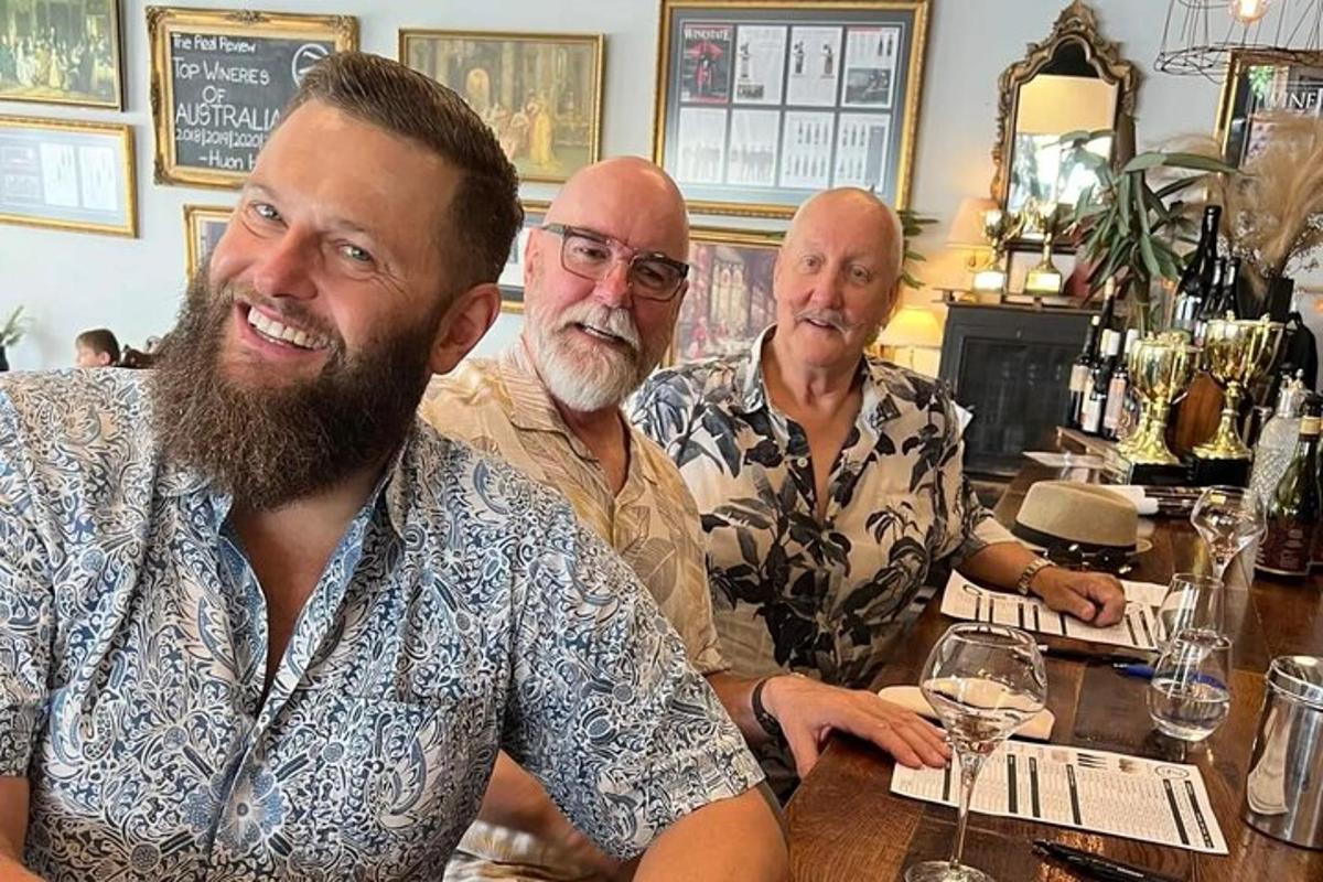 un grup de tres homes asseguts en un bar