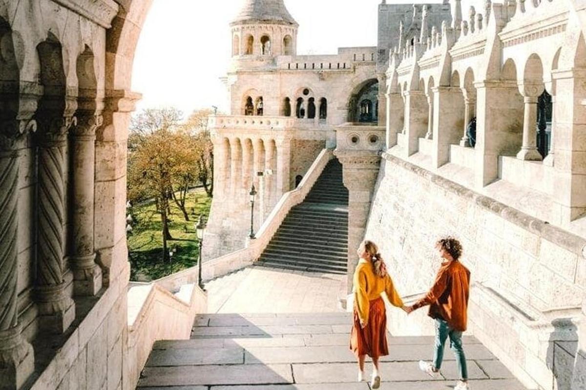um casal de mãos dadas enquanto sobe as escadas de um castelo