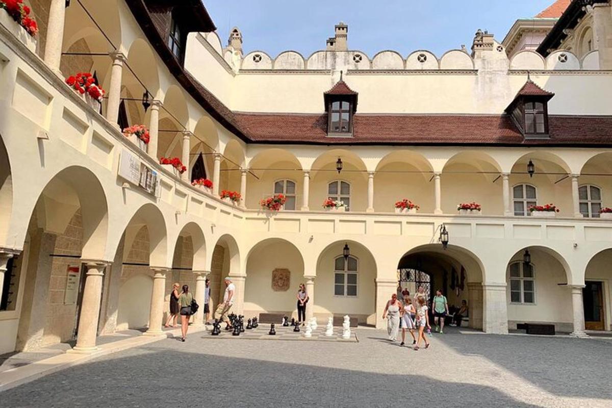 skupina lidí procházejících se po nádvoří budovy
