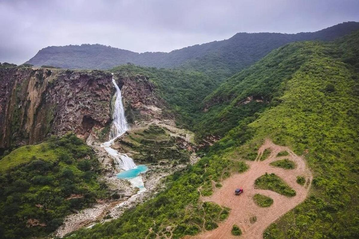 an aerial view of a waterfall in the mountains