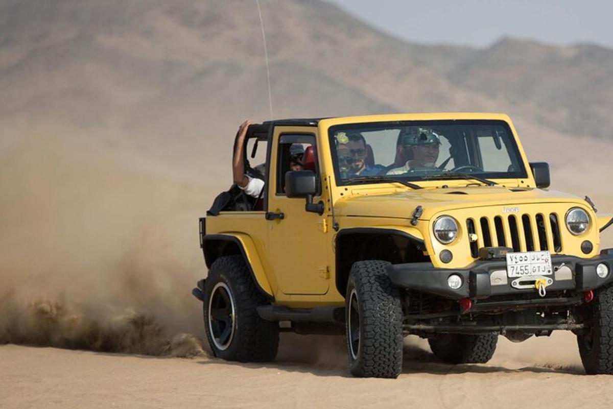 a yellow jeep driving in the desert
