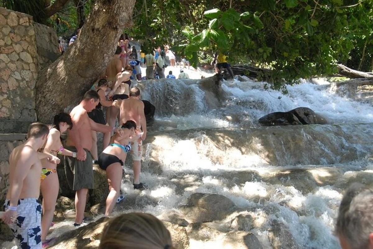 um grupo de pessoas em pé perto de uma cachoeira