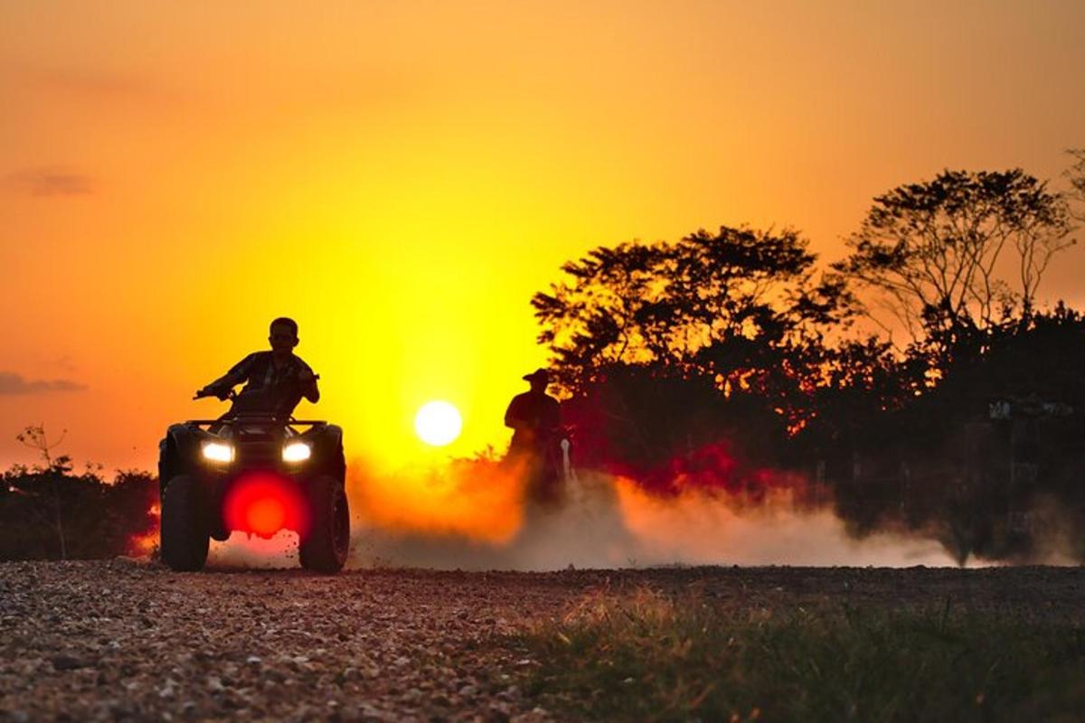 a person riding a quad bike at sunset