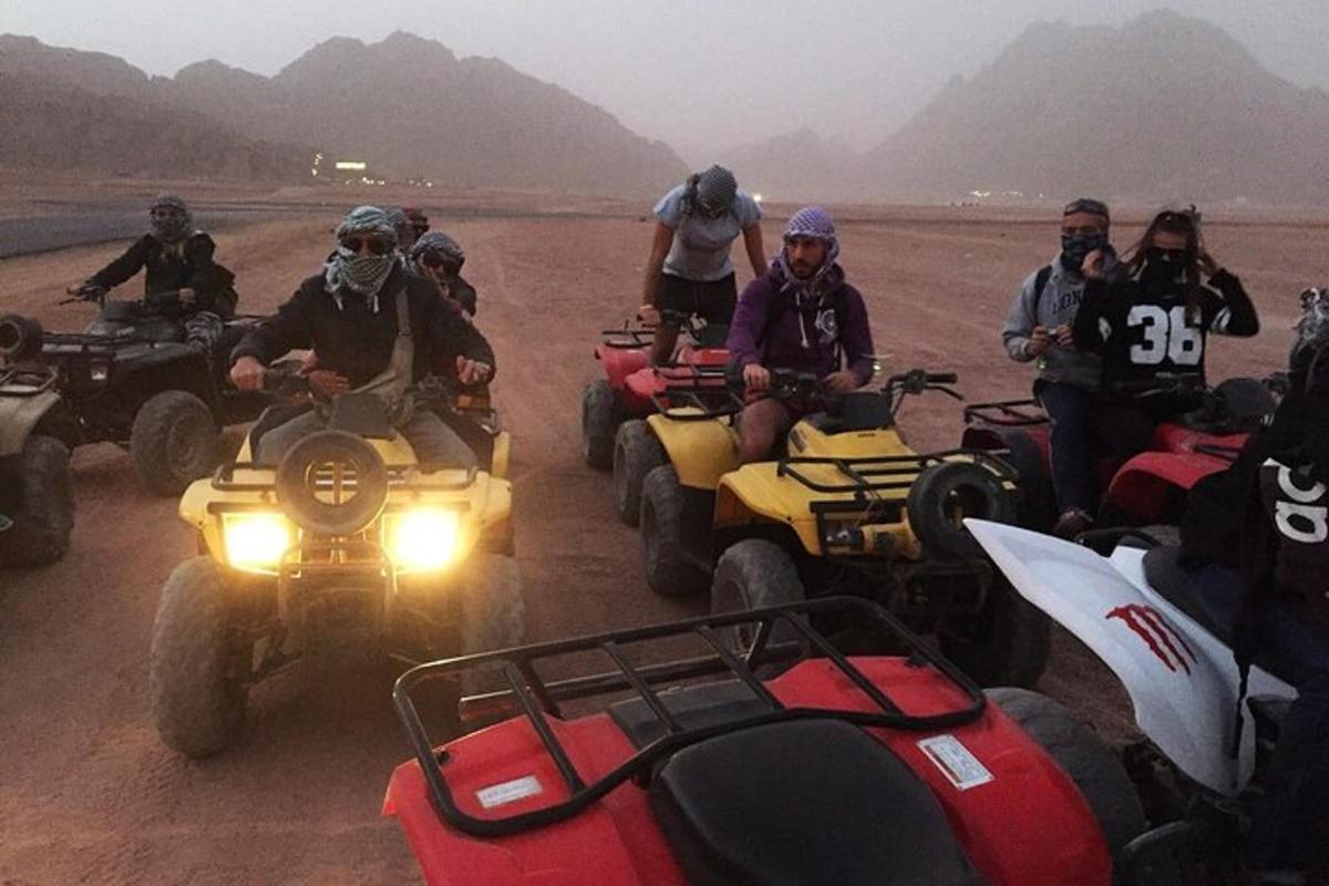 a group of people riding atvs in the desert