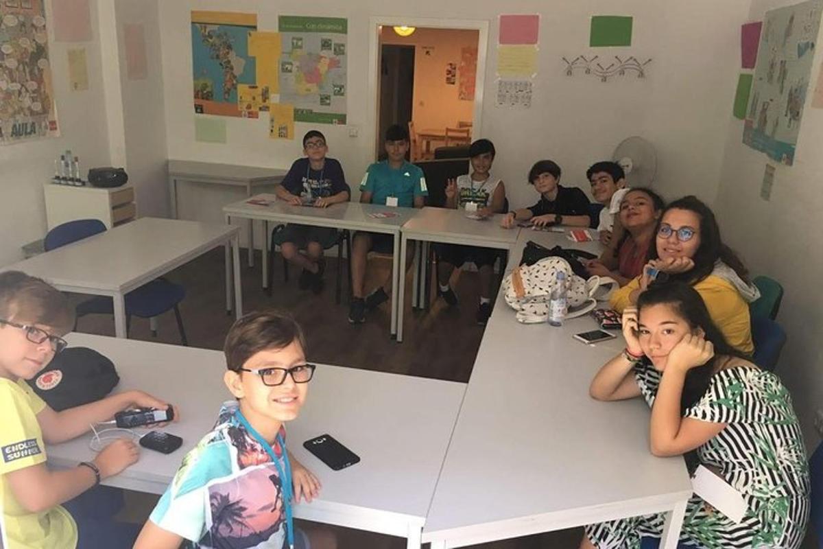 Un grupo de personas sentadas en mesas en un aula.