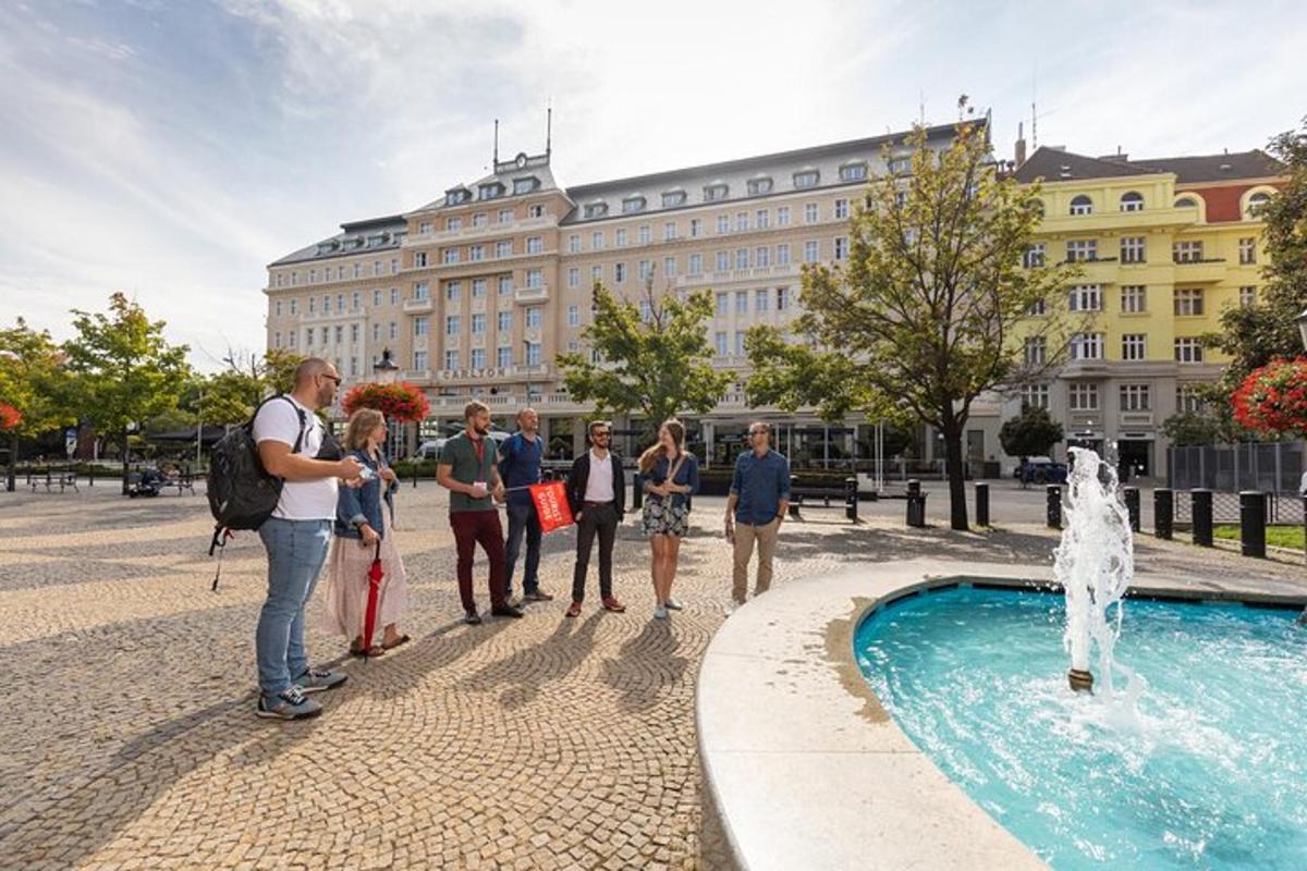 un gruppo di persone in piedi davanti a una fontana