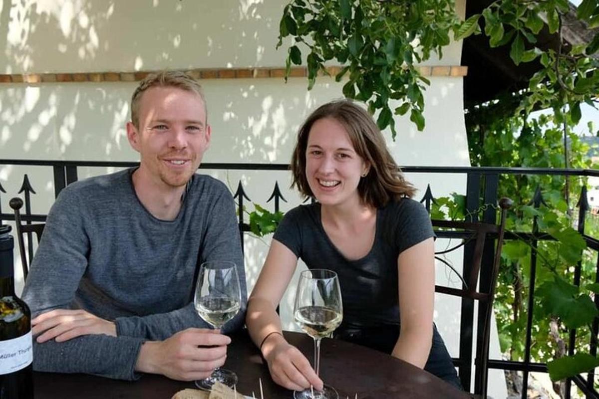 een man en een vrouw zitten aan een tafel met wijnglazen