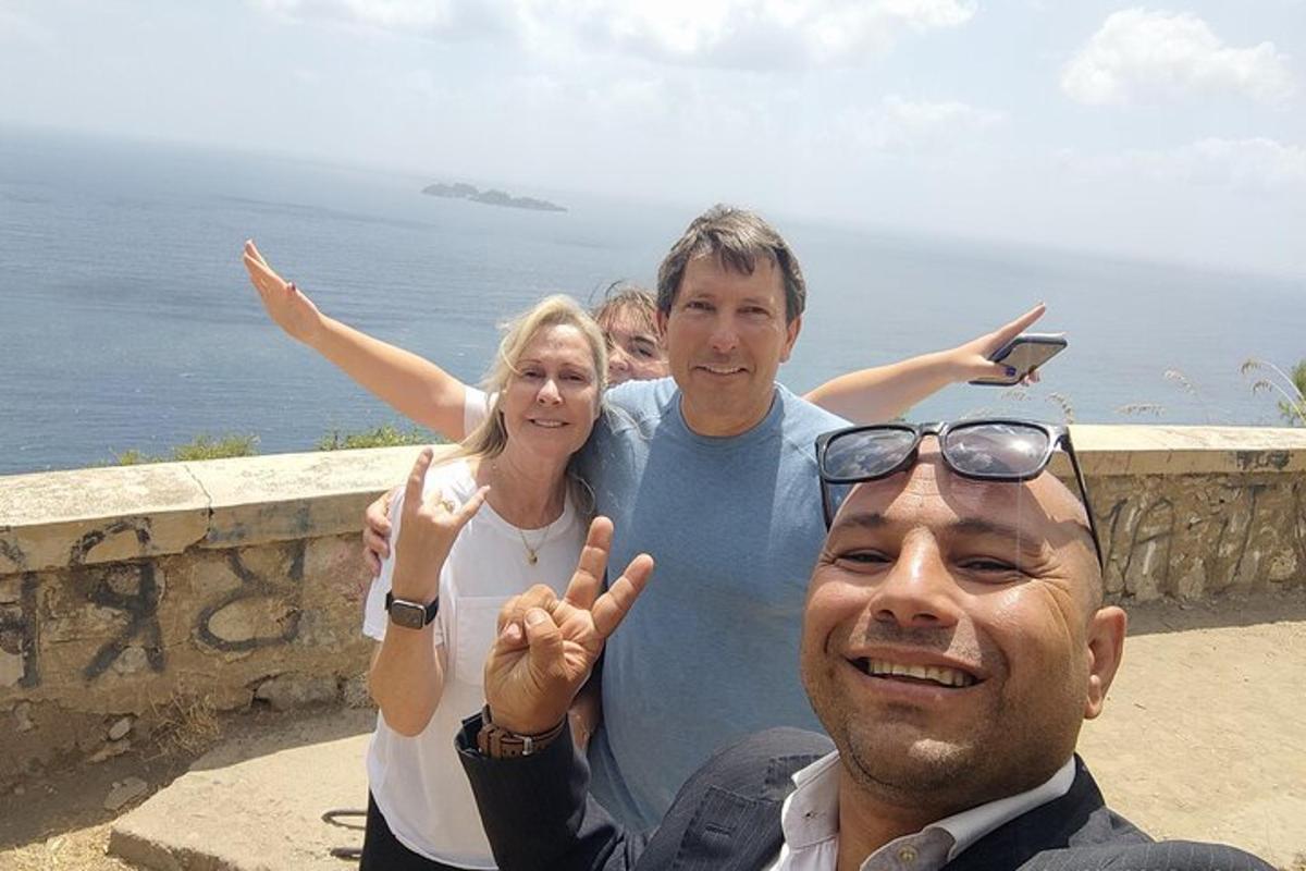 trije ljudje pozirajo za sliko z oceanom v ozadju