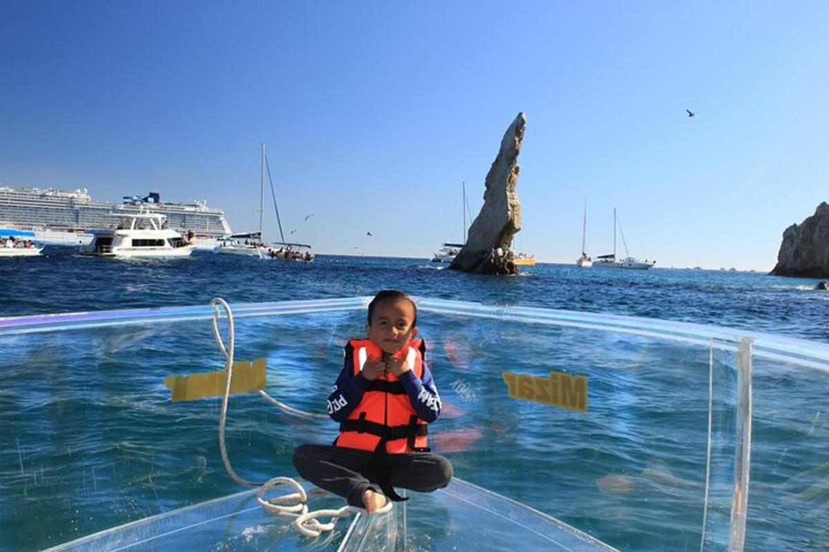Una niña sentada en una mesa de cristal en el agua.