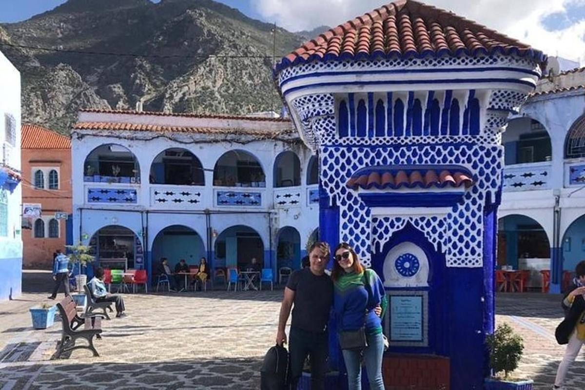 a man and woman standing in front of a blue and white building