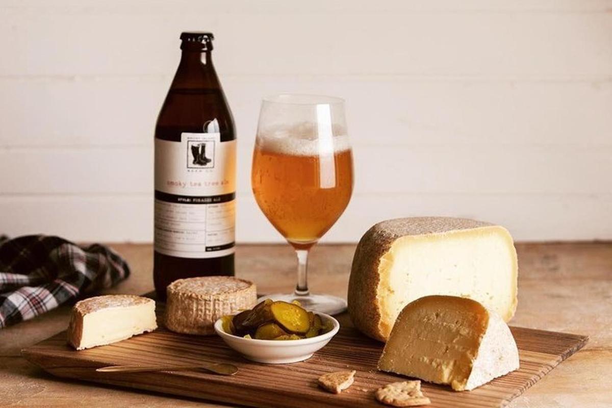 una bottiglia di birra e un bicchiere di formaggio e pane