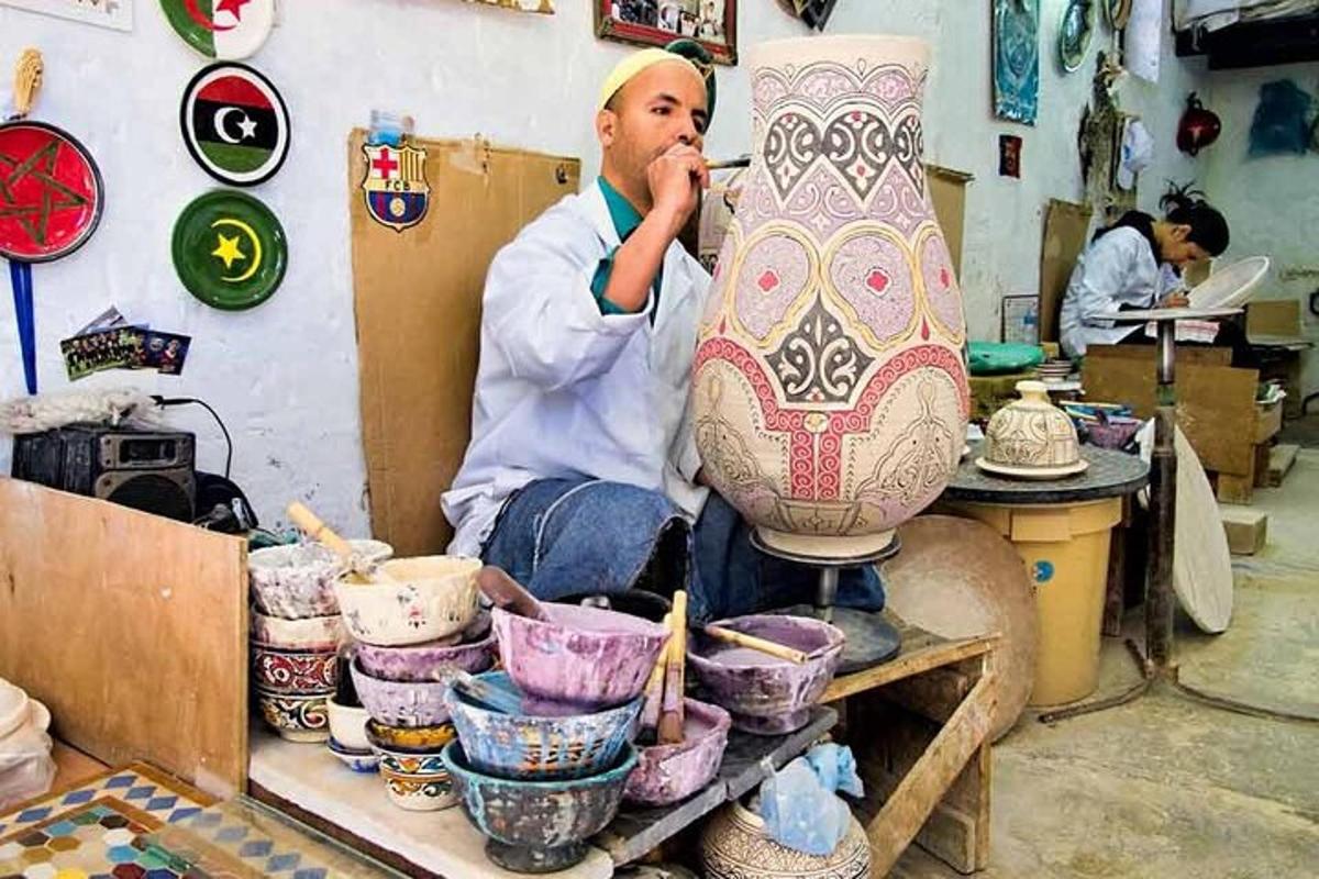 un uomo seduto su un tavolo con un grande vaso