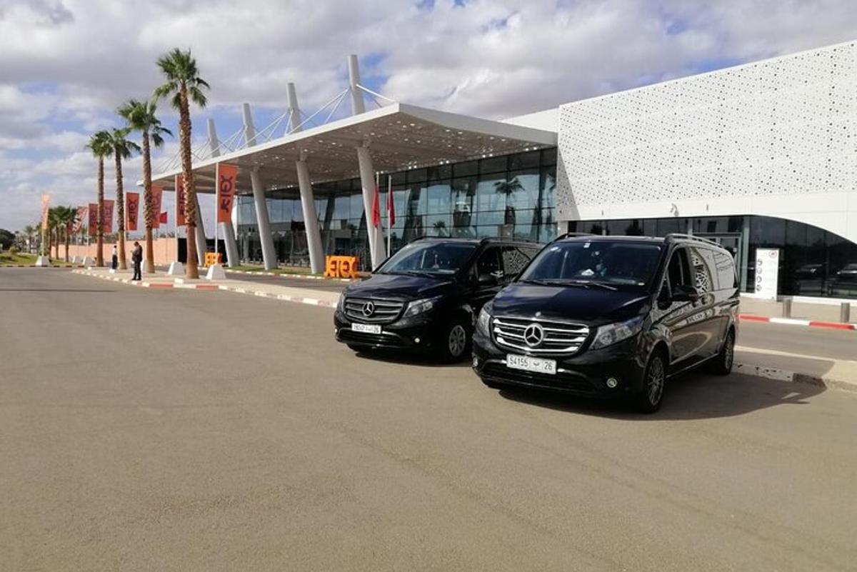 due auto parcheggiate davanti a un edificio con palme