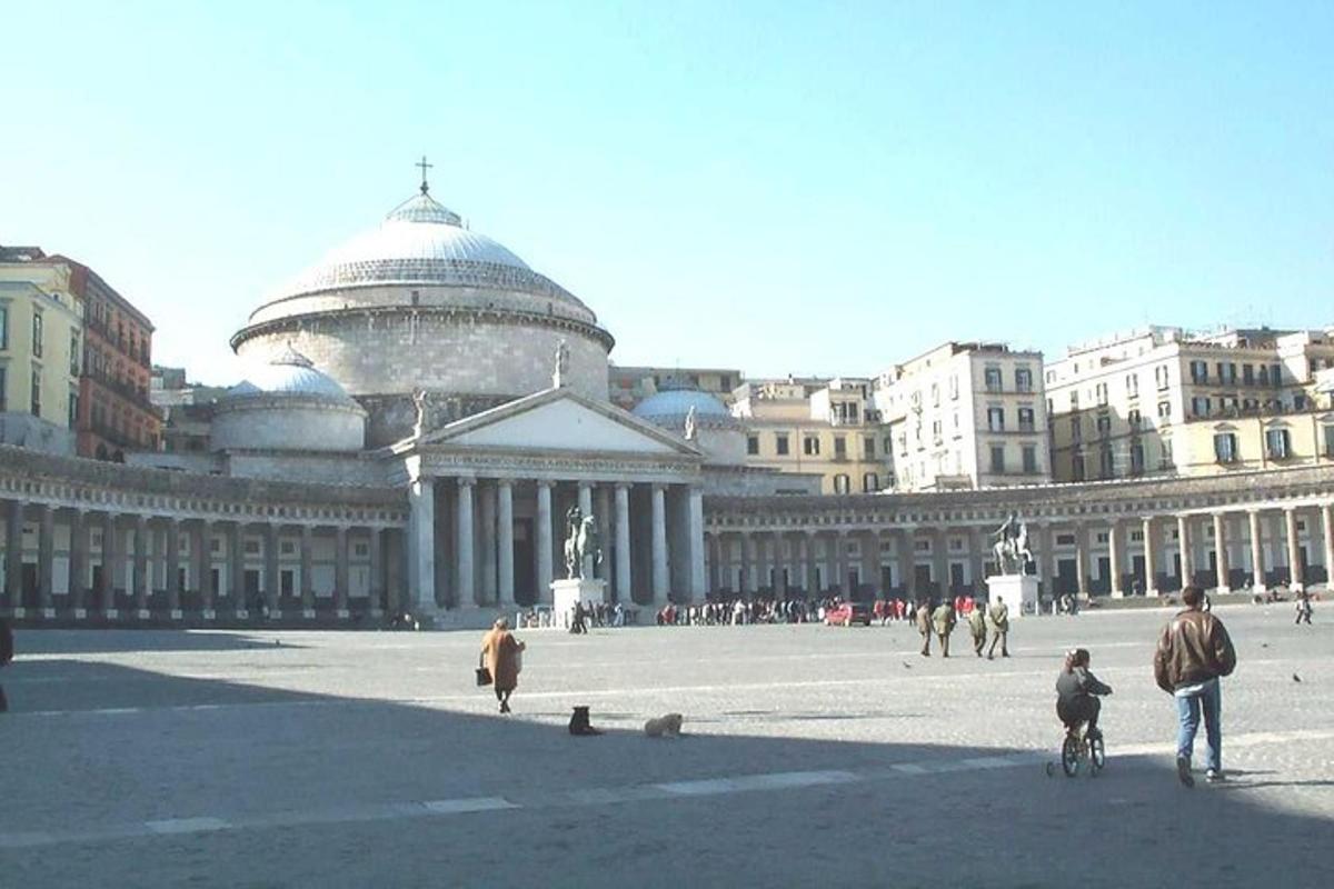 um grupo de pessoas caminhando ao redor de um grande edifício