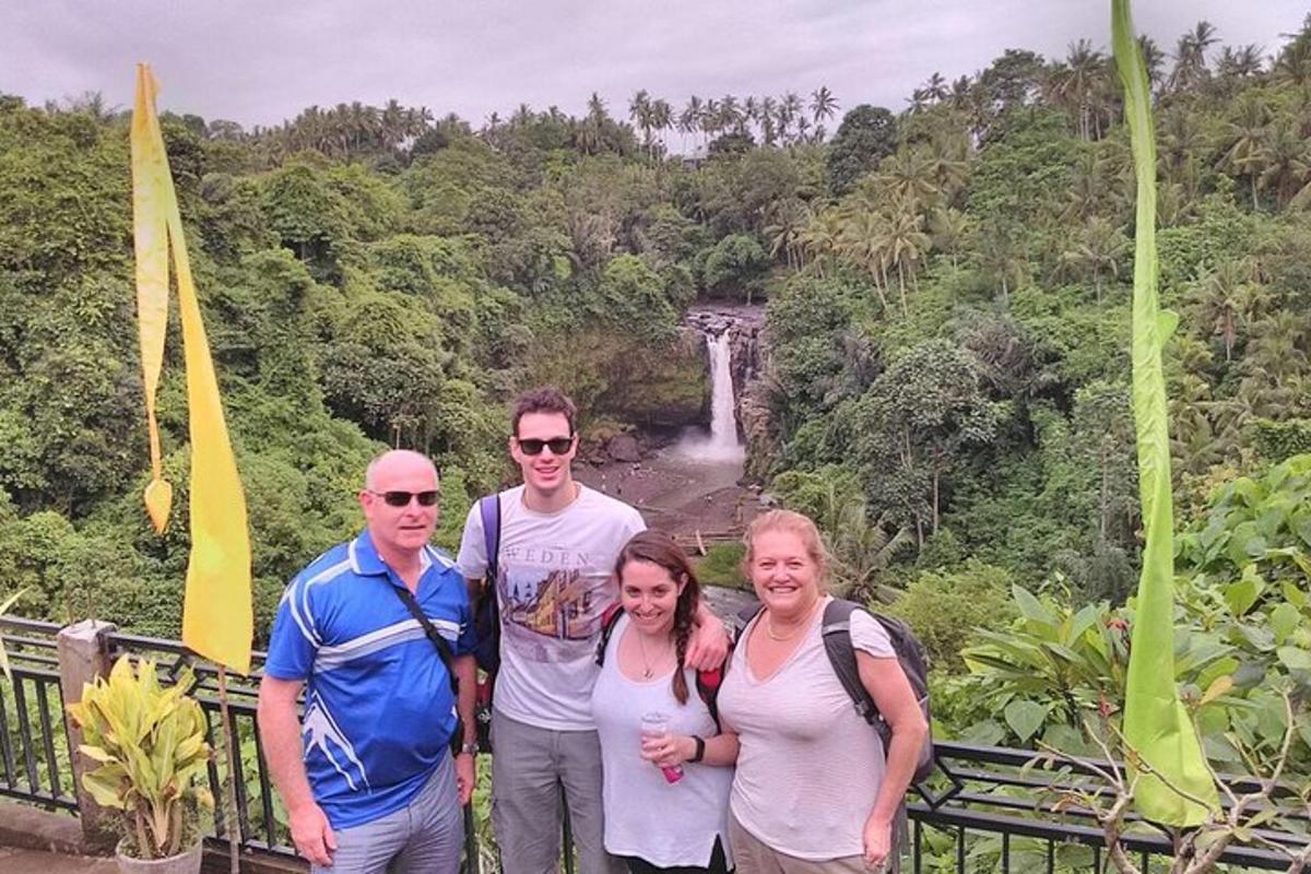 eine Gruppe von Menschen steht vor einem Wasserfall