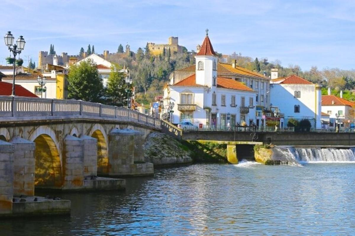 most čez reko z zgradbami in slapom