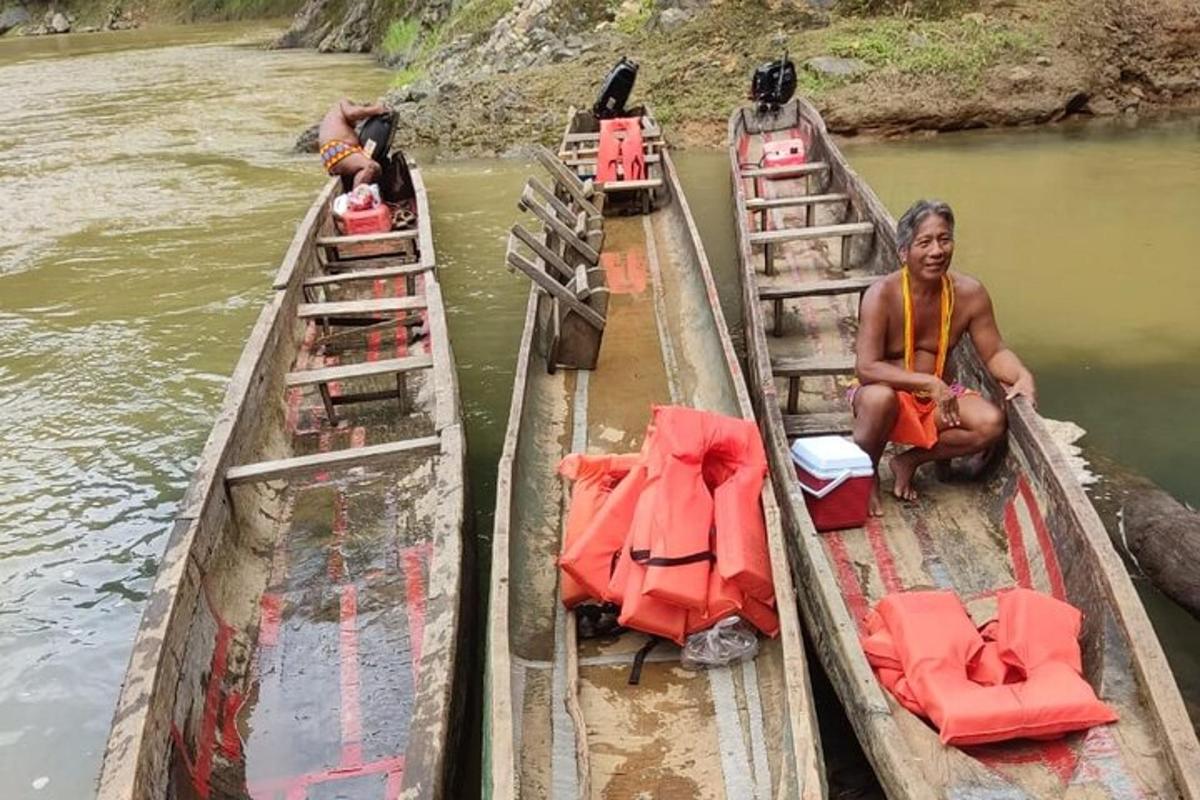 duas pessoas sentadas em dois barcos em um rio