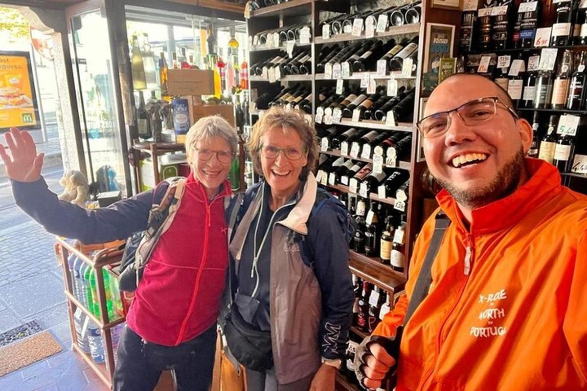 tre persone sono in piedi in un negozio con bottiglie di vino