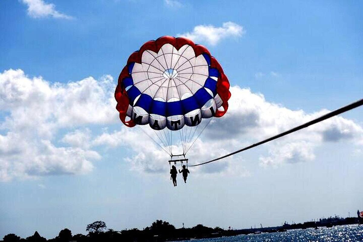 a person flying a parachute in the sky