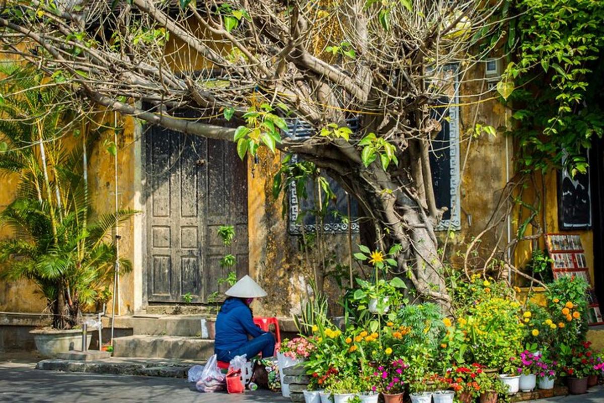 一位女士坐在一栋有鲜花的建筑前