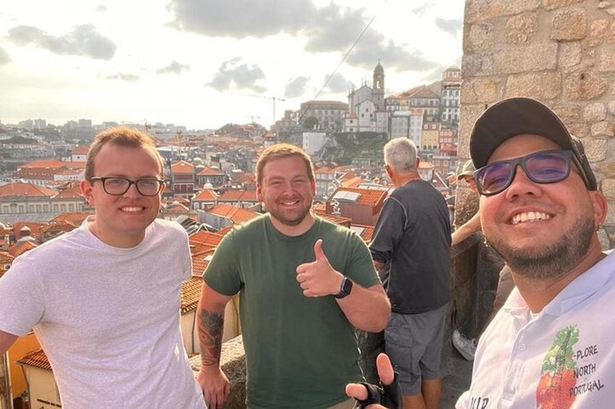 tre uomini in piedi in cima a un edificio che fanno un gesto di pollice in su