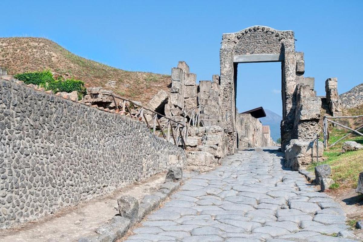 um caminho de pedra com um arco em um muro de pedra
