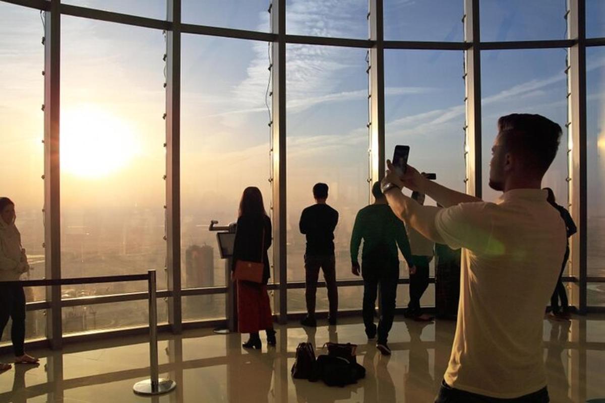 Un hombre tomando una fotografía de un grupo de personas en un edificio.
