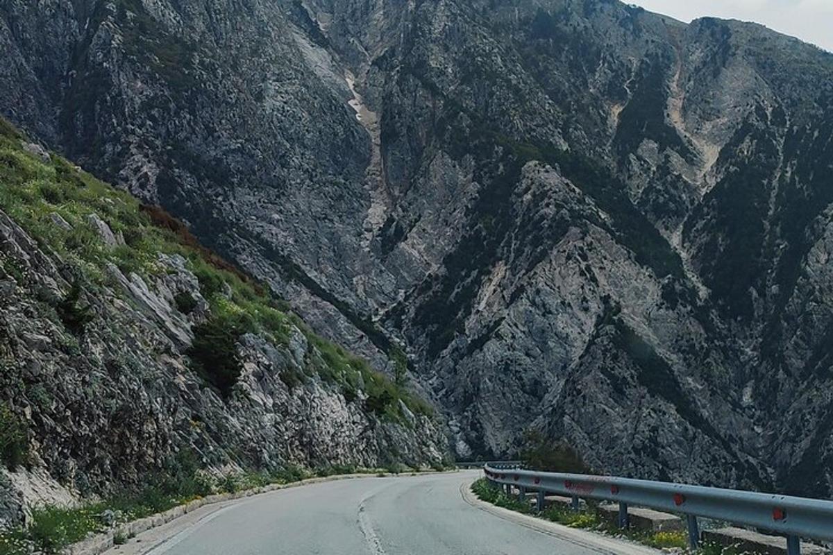un'auto che percorre una strada di fronte a una montagna