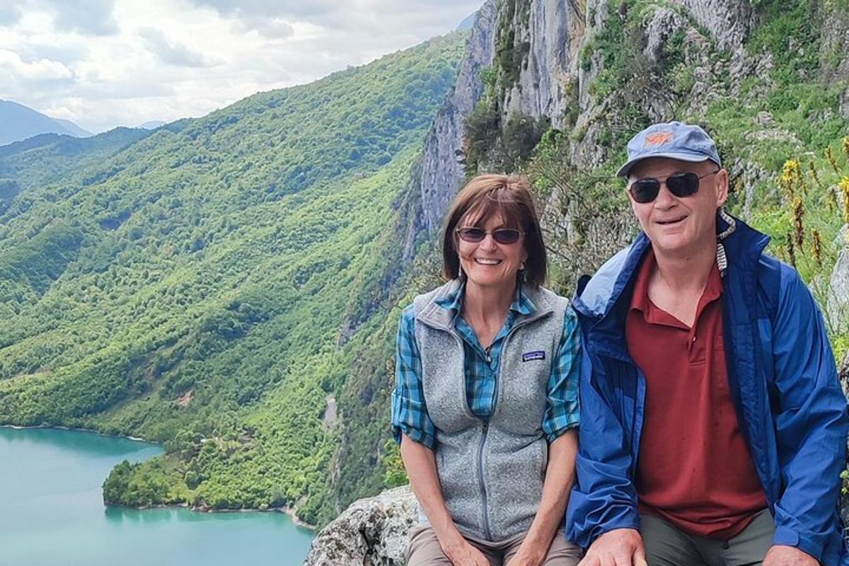 un uomo e una donna seduti in cima a una montagna