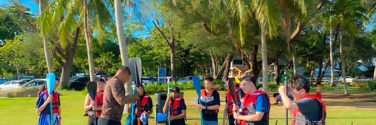 sekumpulan orang berdiri di bawah pokok palma