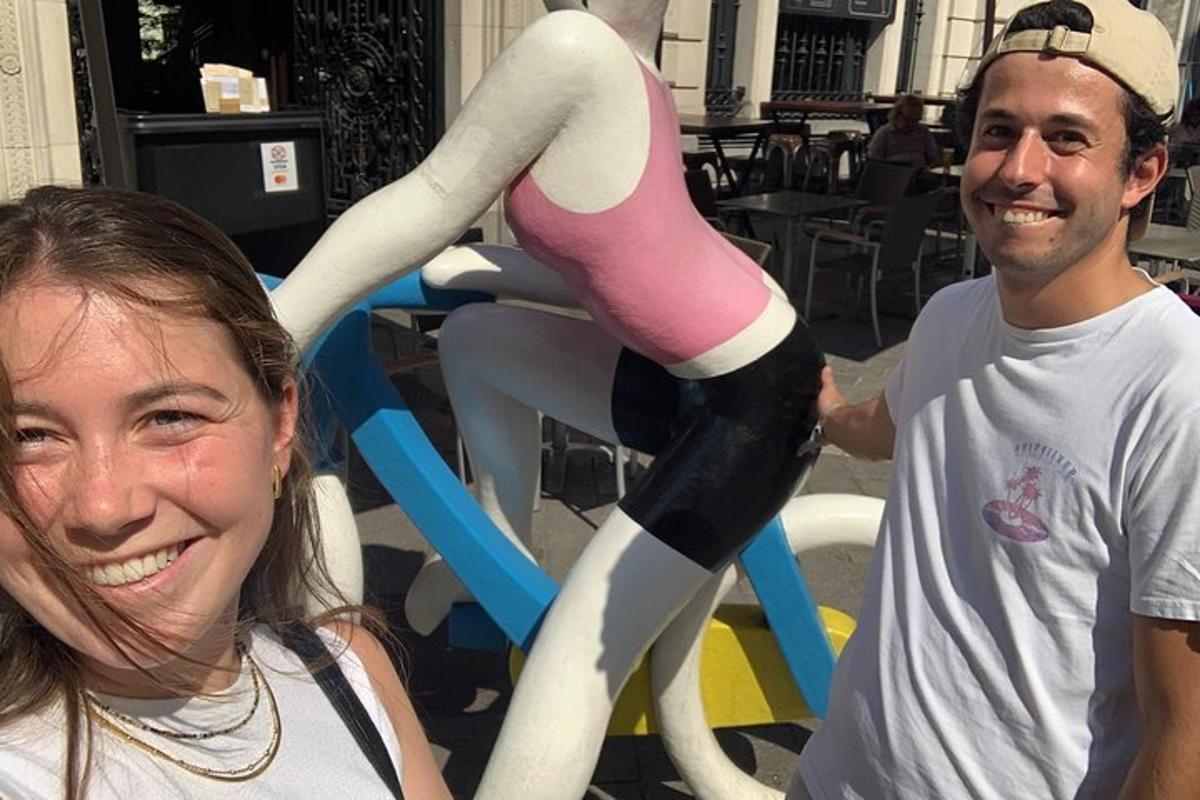 a man and a woman standing in front of a statue