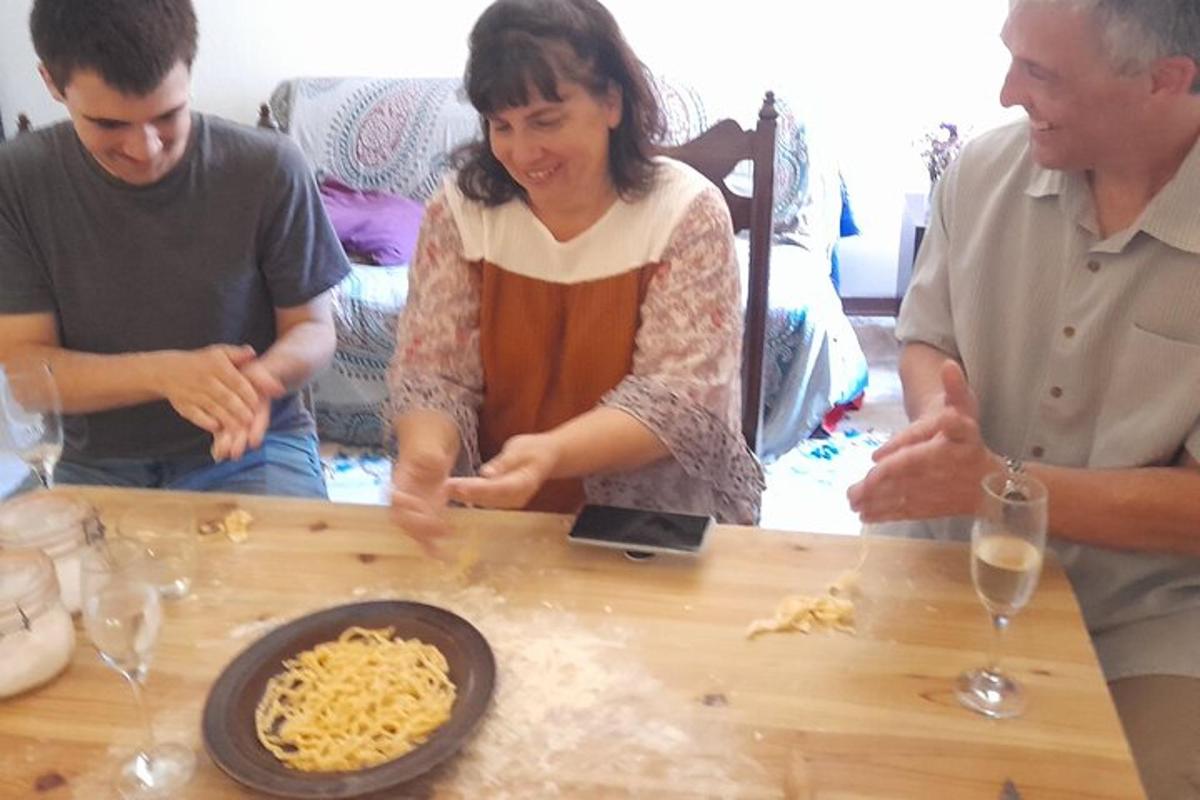 un gruppo di persone in piedi attorno a un tavolo con i noodles