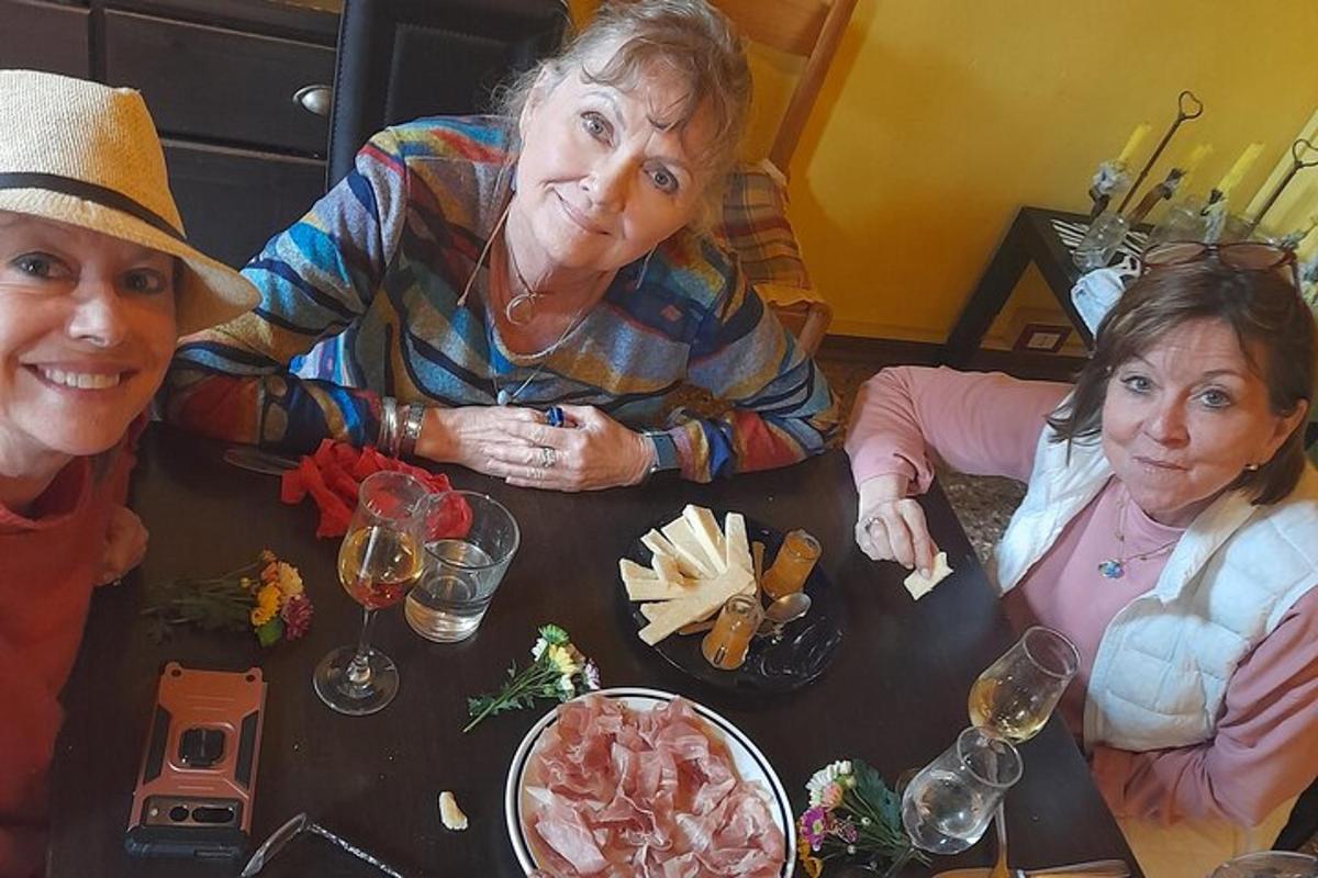 un gruppo di tre donne sedute a un tavolo con del cibo