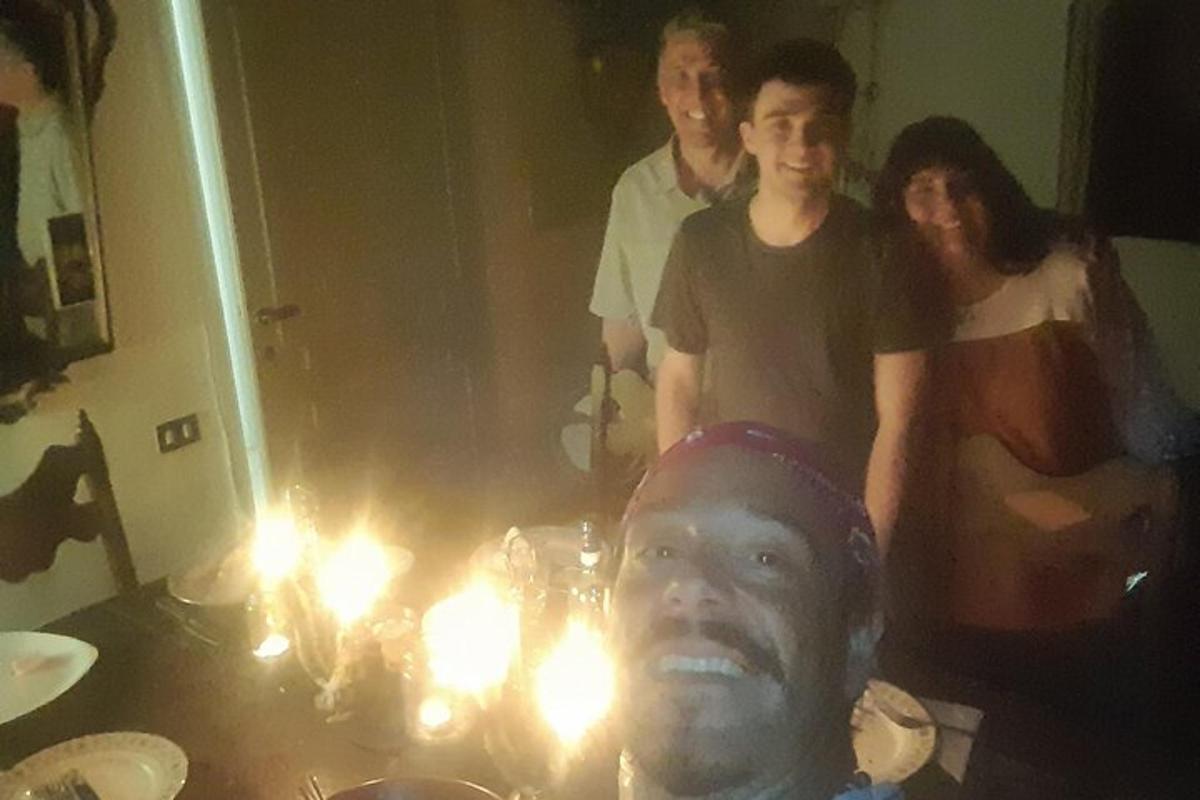 un gruppo di persone in piedi attorno a un tavolo con candele accese