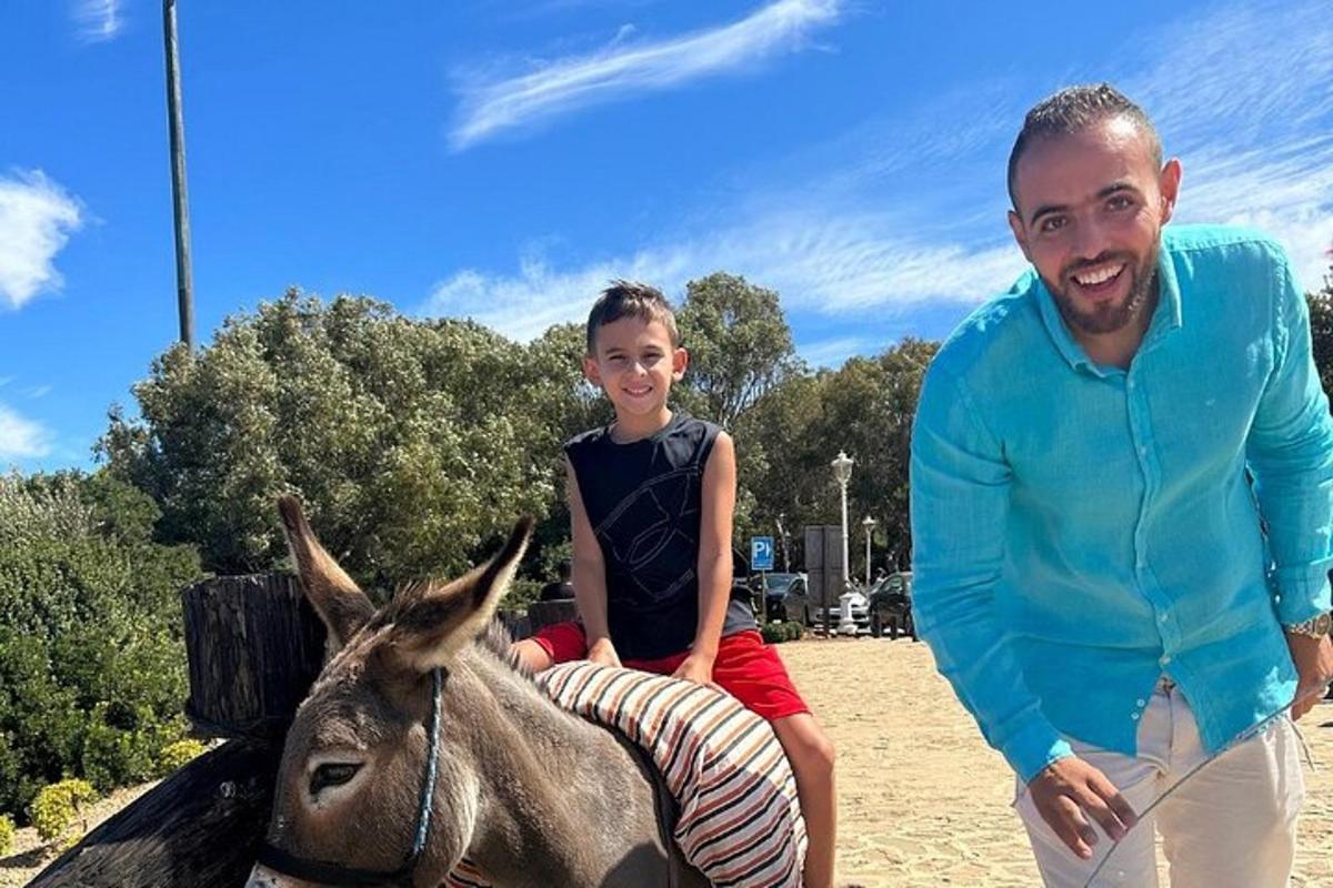 a man and a young boy sitting on a donkey