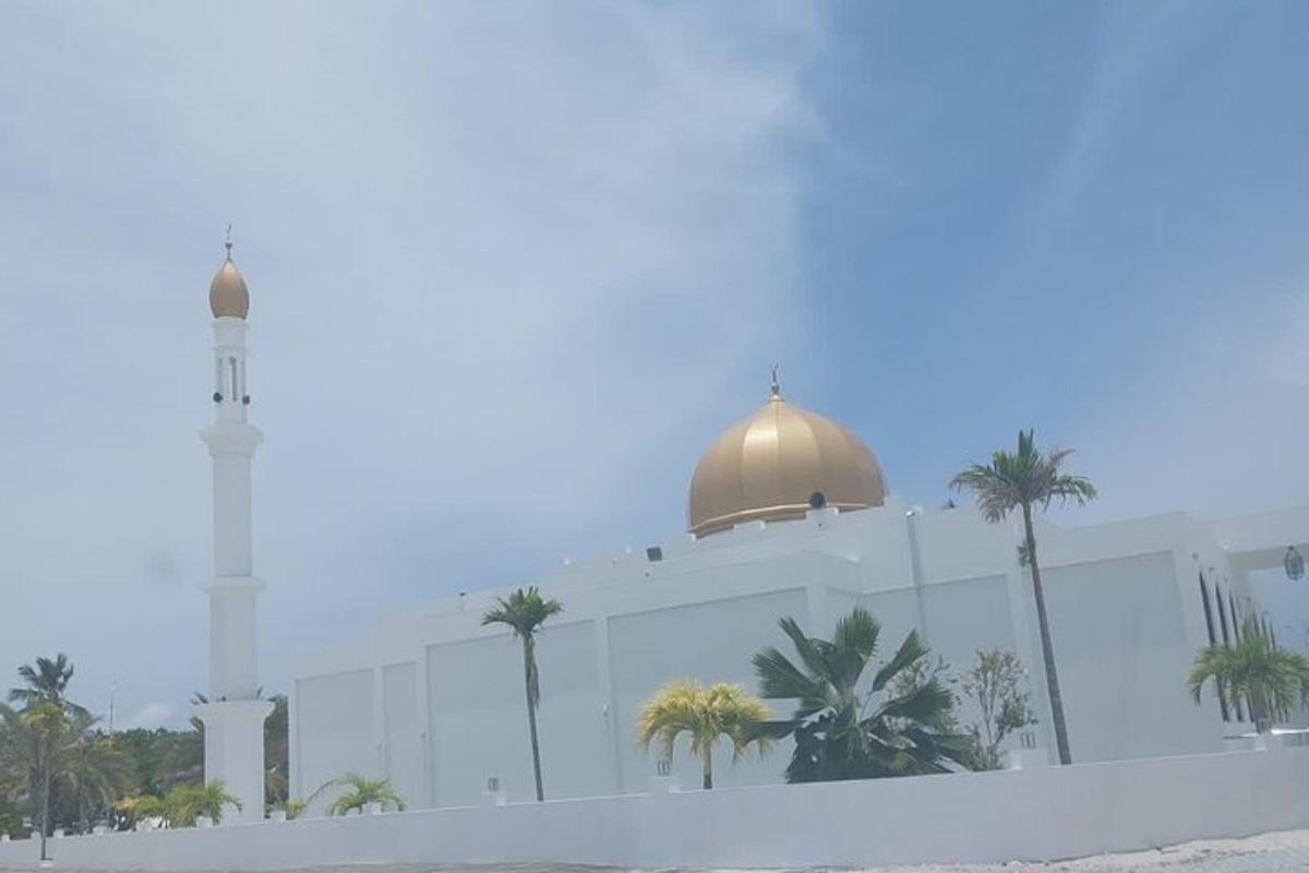 a mosque with a clock tower and palm trees