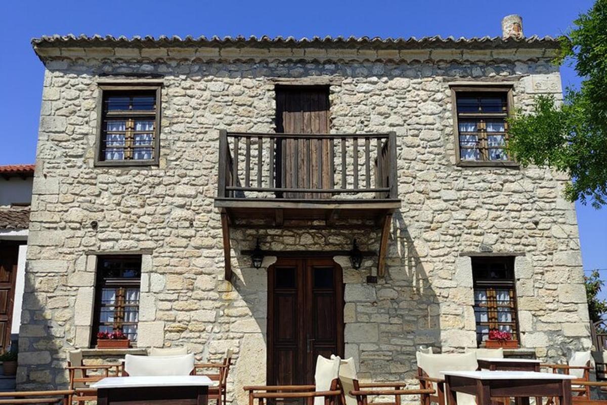 o clădire din piatră cu balcon, mese și scaune