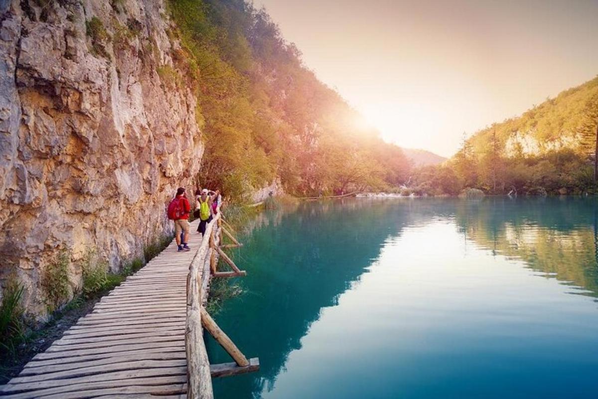 sekumpulan orang berjalan di atas jambatan di atas sungai